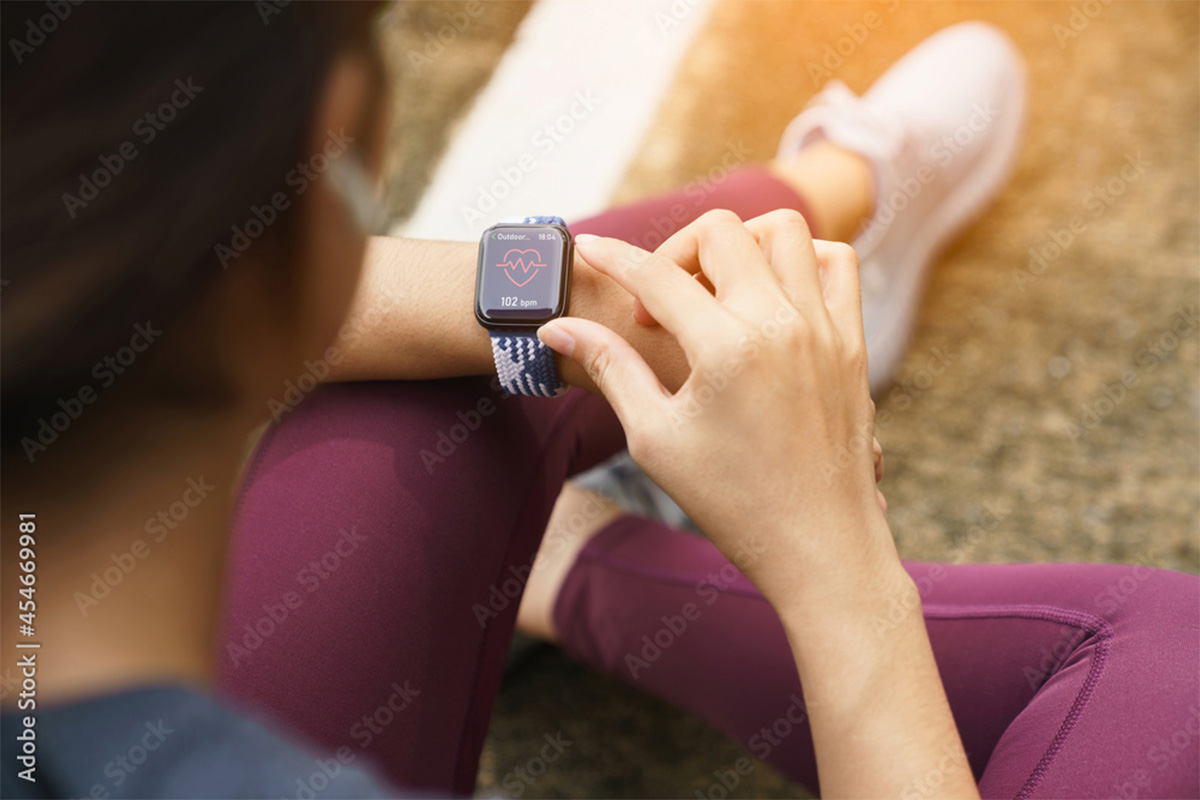 woman using smartwatch while jogging